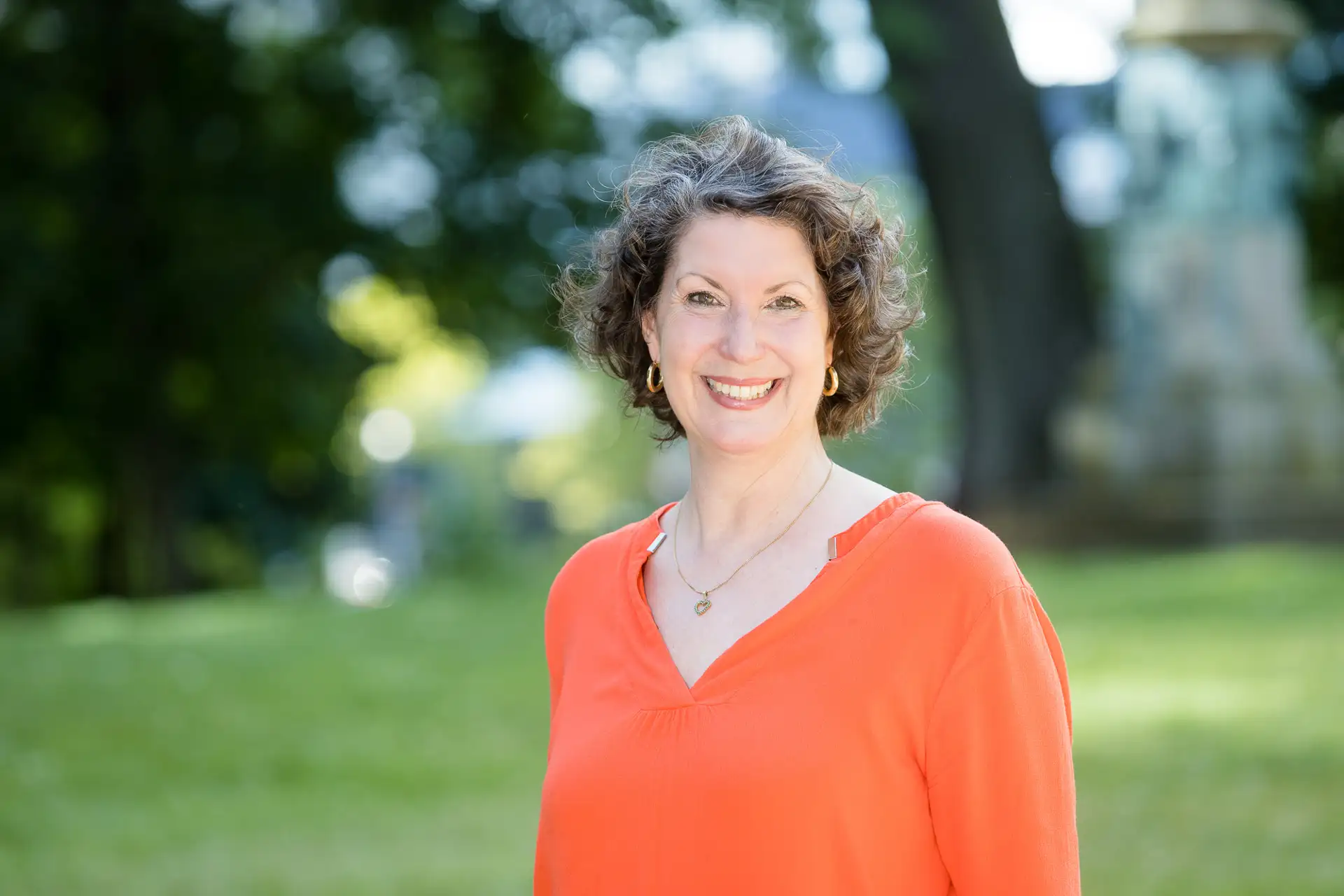 Marion Hirschbach Persoenlichkeitsentwicklung Coaching - Frau laechelt und steht in der Natur